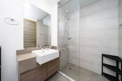 a white bathroom with a sink and a shower at Luxury JVC Studio in a Great Location in Dubai