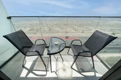 three chairs and a table on a balcony with a view at Luxury JVC Studio in a Great Location in Dubai