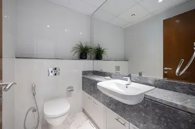 a white bathroom with a sink and a toilet at 5 Star Amenities 10 Mins Downtown Kite Beach in Dubai