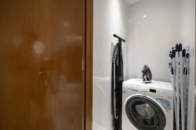 a laundry room with a washer and a washing machine at 5 Star Amenities 10 Mins Downtown Kite Beach in Dubai