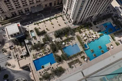 an overhead view of a hotel with two pools at 5 Star Amenities 10 Mins Downtown Kite Beach in Dubai