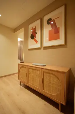 a living room with a wooden cabinet and two pictures at 2 bedroom Apartment Dubai Marina in Dubai