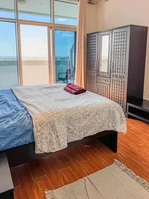 a bedroom with a bed and a large window at Luxury Studio in JVT in Dubai