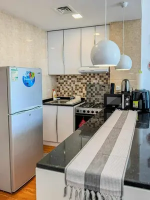 a kitchen with a refrigerator and a counter top at Luxury Studio in JVT in Dubai