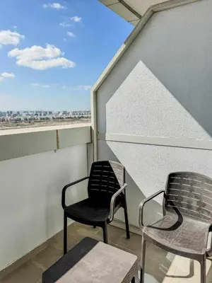 two chairs and a table on a balcony at Luxury Studio in JVT in Dubai