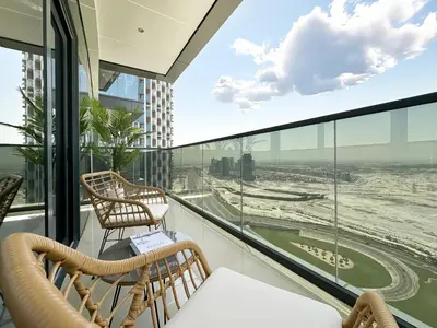 a balcony with two chairs and a view of an airport at Trophy-Luxe Living in a Blue-Hued Haven in Dubai