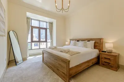 a bedroom with a large bed and a large window at Al Tajer Residence, Oldtown - 1BR Apartment - Allsopp & Allsopp in Dubai