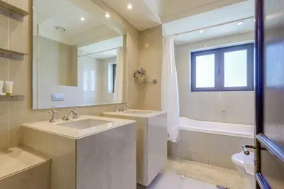a bathroom with two sinks and a tub and a mirror at Al Tajer Residence, Oldtown - 1BR Apartment - Allsopp & Allsopp in Dubai