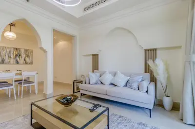 a living room with a couch and a table at Al Tajer Residence, Oldtown - 1BR Apartment - Allsopp & Allsopp in Dubai