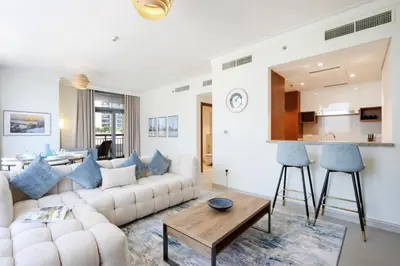 a living room with a white couch and a table at Livbnb Creekfront 2BR with Skyline Views Steps to Creek Marina in Dubai