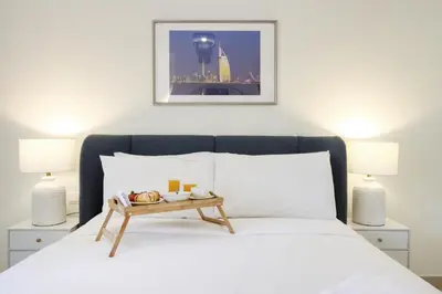 a bedroom with a bed with a tray of food on it at Livbnb Creekfront 2BR with Skyline Views Steps to Creek Marina in Dubai