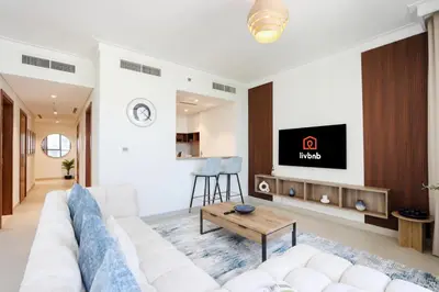 a living room with a white couch and a tv at Livbnb Creekfront 2BR with Skyline Views Steps to Creek Marina in Dubai