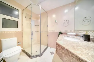 a bathroom with a shower and a toilet and a sink at Stella Stays Barsha Heights in Dubai