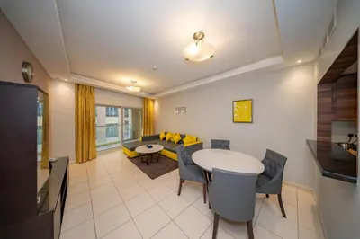 a living room with a couch and a table and chairs at City Stay Prime Hotel Apartments - Al Barsha in Dubai