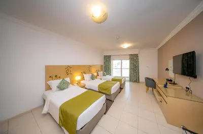 a hotel room with two beds and a flat screen tv at City Stay Prime Hotel Apartments - Al Barsha in Dubai