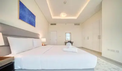 a large white bedroom with a large white bed at Dubai Marina Sea View hotel Apartment in Dubai