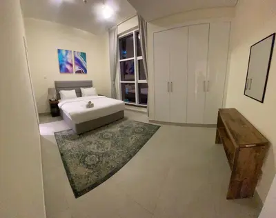 a bedroom with a white bed and a large window at Dubai Marina Sea View hotel Apartment in Dubai