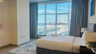 a hotel room with a bed and a large window at Dubai Marina Sea View hotel Apartment in Dubai