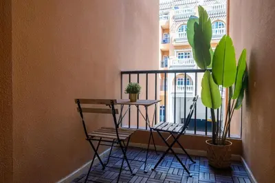 a balcony with a table and two chairs and a plant at Retro House in Dubai