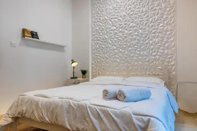 a bedroom with a white bed with towels on it at Retro House in Dubai