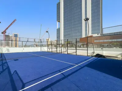 a tennis court in front of a building at FIRST CLASS Studio Contemporary Living in JVT in Dubai