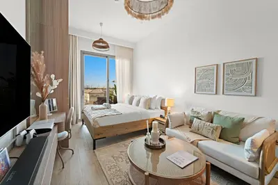 a living room with a couch and a tv at FIRST CLASS Studio Contemporary Living in JVT in Dubai