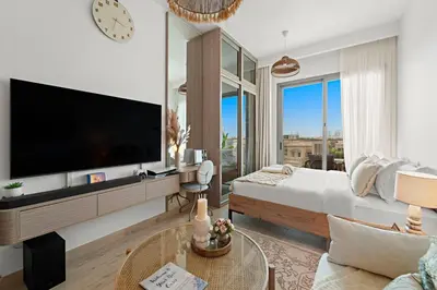 a living room with a large flat screen tv at FIRST CLASS Studio Contemporary Living in JVT in Dubai