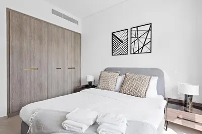 a white bedroom with a large bed and a couch at Vayk - Modern 2BR with Private Plunge Pool in JVC in Dubai