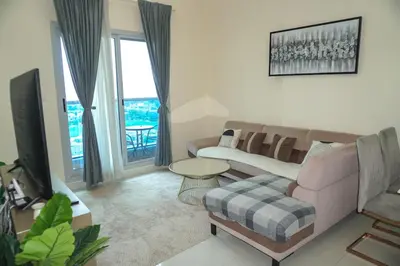 a living room with a couch and a tv at Stylish 1BR in Elite 7 Sports City in Dubai