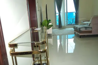 a living room with a glass table and a mirror at Stylish 1BR in Elite 7 Sports City in Dubai