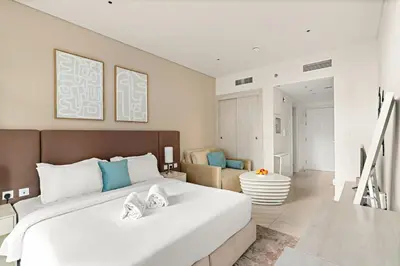 a bedroom with a large bed and a living room at FIRST CLASS Studio Palm Paradise in Dubai