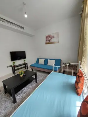 a bedroom with a blue bed and a couch at Damac Hills 2- 3BR Townhouse - Homeyvillas in Dubai
