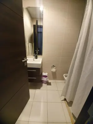 a bathroom with a sink and a toilet and a door at Damac Hills 2- 3BR Townhouse - Homeyvillas in Dubai