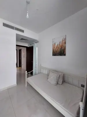 a bed in a white room with a picture on the wall at Damac Hills 2- 3BR Townhouse - Homeyvillas in Dubai