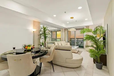 a dining room and living room with a table and chairs at Luxury 2BR with City Skyline Views Steps to JBR Beach & Marina Mall in Dubai