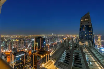 a city skyline at night with a tall building at Luxury 2BR with City Skyline Views Steps to JBR Beach & Marina Mall in Dubai