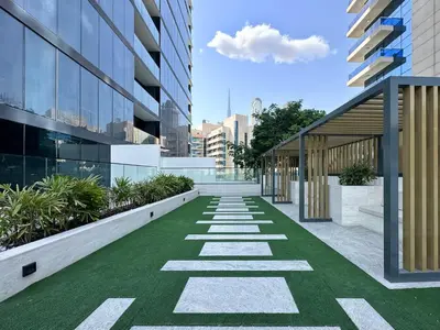 a walkway in a building with green grass at Luxe Living in the Heart of Bbay w Jacuzzi in Dubai