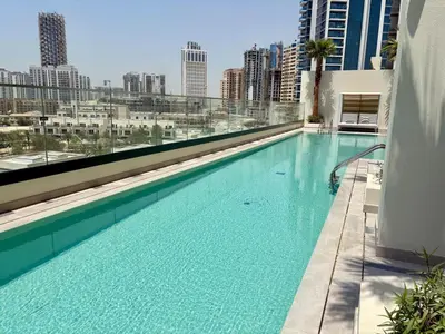 a large swimming pool on the roof of a building at Stylish Studio in JVC with Pool, Gym, Balcony & Modern Comforts in Dubai