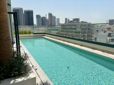 a swimming pool on the roof of a building at Stylish Studio in JVC with Pool, Gym, Balcony & Modern Comforts in Dubai