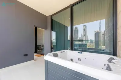 a bath tub in a bathroom with a large window at Blue Breeze - Luxurious 1BR with Private Jacuzzi & Burj View in Dubai