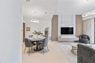 a living room with a table and chairs and a tv at Act tower-1BR near Burj Khalifa in Dubai
