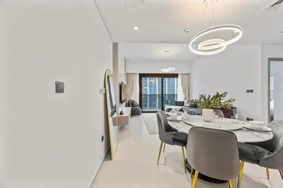 a dining room and living room with a table and chairs at Act tower-1BR near Burj Khalifa in Dubai
