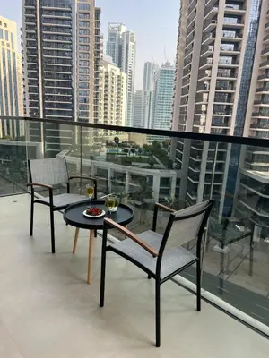 a table and chairs on a balcony with a view of a city at Act tower-1BR near Burj Khalifa in Dubai