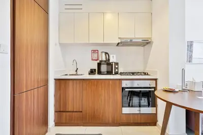 a kitchen with a sink and a stove at Modern 1 Bed with Burj View From Balcony & Pool and Gym Access in Dubai