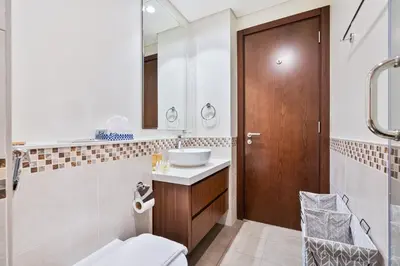 a bathroom with a sink and a wooden door at Modern 1 Bed with Burj View From Balcony & Pool and Gym Access in Dubai