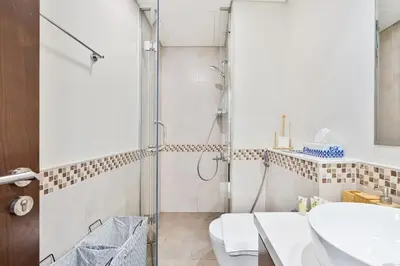 a bathroom with a shower and a toilet and a sink at Modern 1 Bed with Burj View From Balcony & Pool and Gym Access in Dubai
