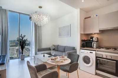 a kitchen and living room with a table and a couch at EasyGo-Modern, Distinguished with Sofa Bed in Dubai