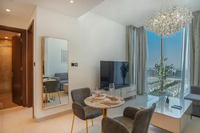 a living room with a table and chairs and a television at EasyGo-Modern, Distinguished with Sofa Bed in Dubai