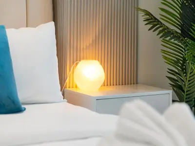 a bed with a table with a lamp on it at Exclusive 1BD with Burj View & Private Jacuzzi in Dubai