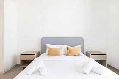 a bedroom with a white bed with two night stands at Restay Homes - Fancy 2BR in Belgravia Heights - Pool access in Dubai